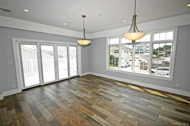 a view of an empty room with a window and chandelier