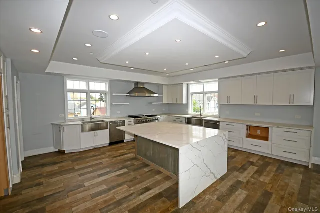 a kitchen with stainless steel appliances a sink stove and wooden floor