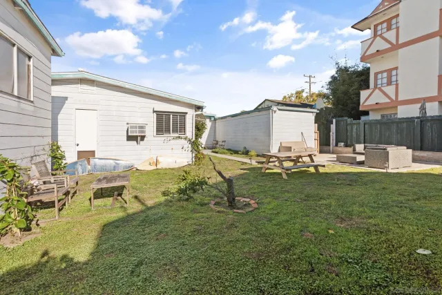 a view of a house with backyard and sitting area