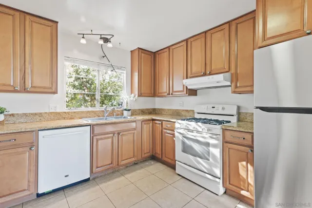 a kitchen with granite countertop appliances cabinets and a sink