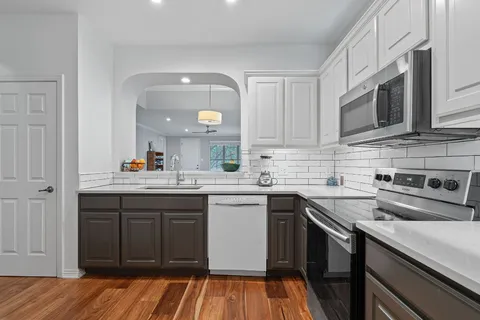 a kitchen with stainless steel appliances granite countertop a sink and stove top oven