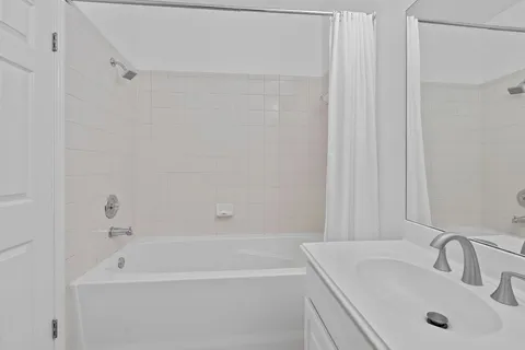 a bathroom with a tub a sink and a shower