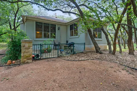 a view of a house with a backyard and a tree