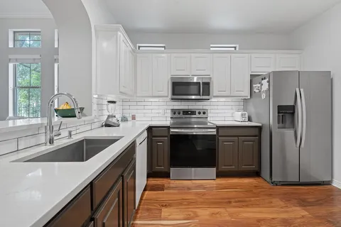 a kitchen with granite countertop a refrigerator sink and stove