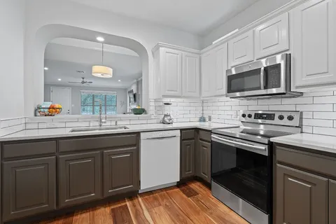 a kitchen with stainless steel appliances granite countertop a sink stove and microwave