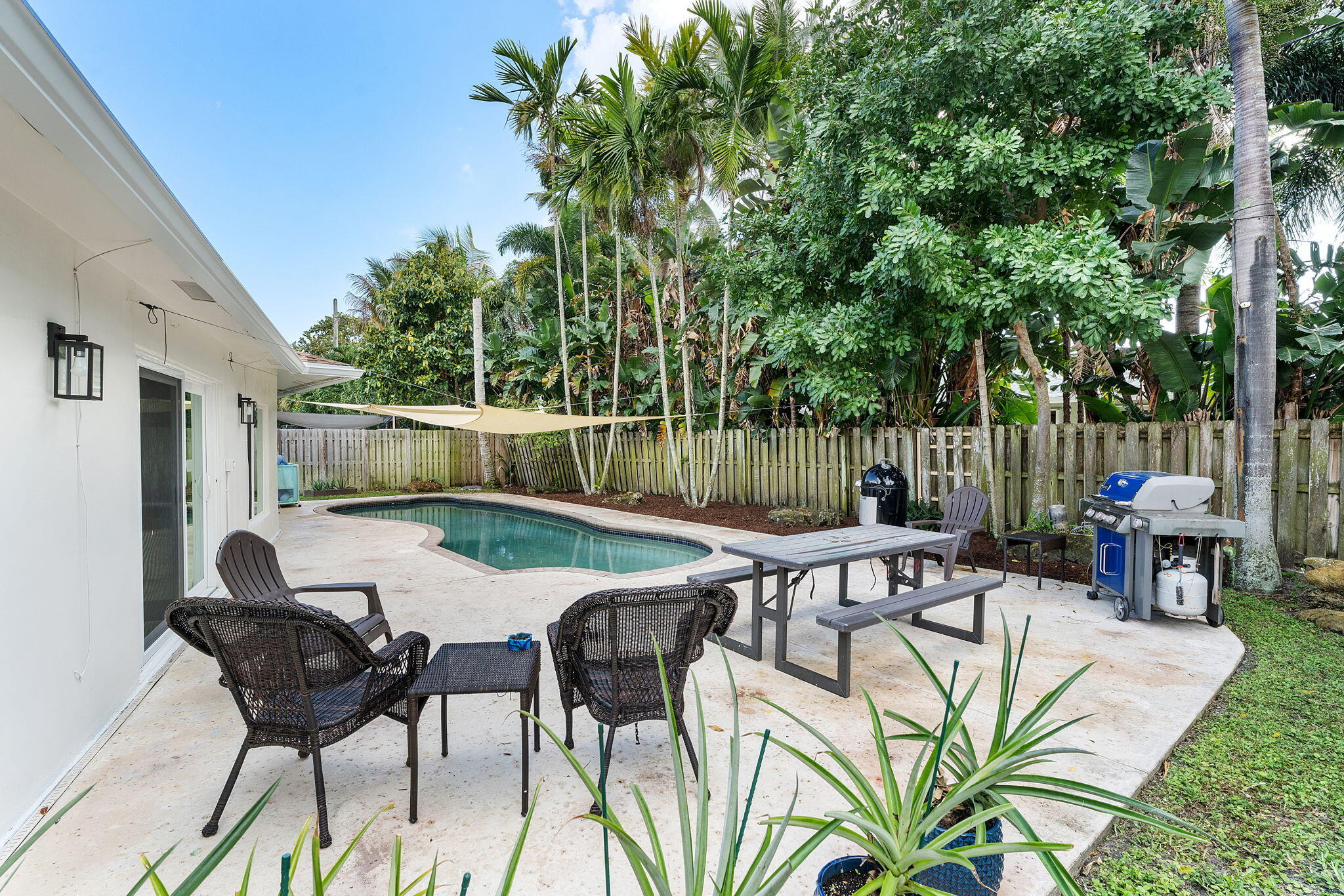 788 Northwest 7th Drive Boca Raton, FL 33486 - Photo 33 of 46 a view of a patio with table and chairs with wooden fence and plants