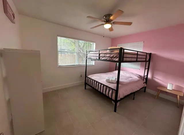 a bedroom with a bed and a ceiling fan in it