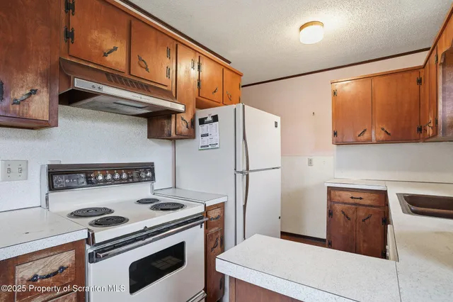 a kitchen with stainless steel appliances a stove a refrigerator and cabinets