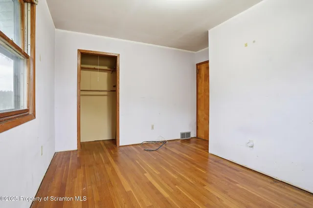 a view of a room with wooden floor and brick walls