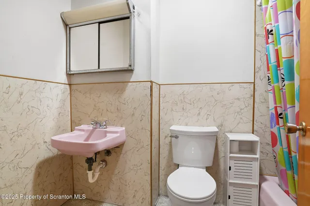 a bathroom with a sink toilet and a mirror