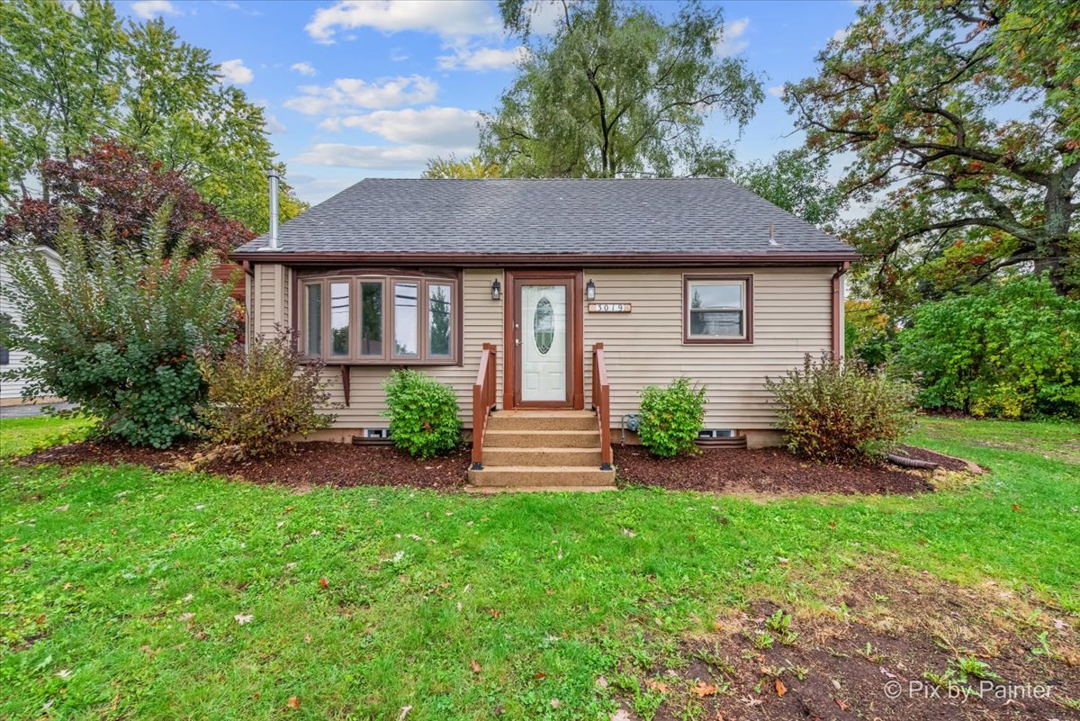a front view of a house with a yard and green space