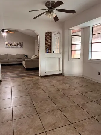 a living room with couches and ceiling fan