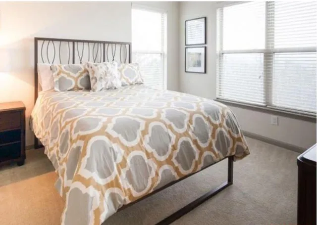 a large bed sitting in a bedroom next to a window