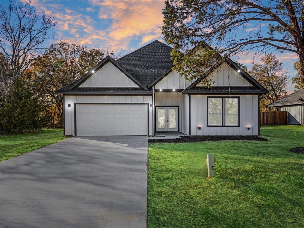 a front view of a house with a garden and yard