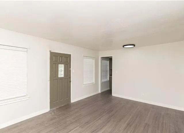 a view of an empty room with wooden floor