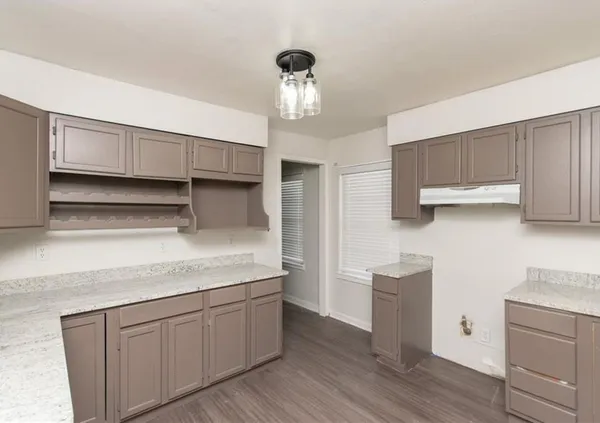 a kitchen with cabinets wooden floor and a stainless steel appliances