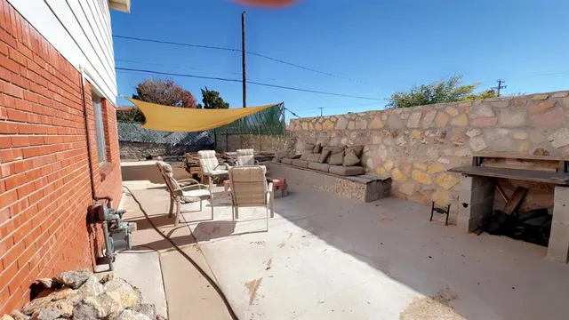 a view of a patio with table and chairs under an umbrella