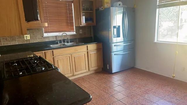 a kitchen with stainless steel appliances granite countertop a refrigerator a sink dishwasher a stove and white countertops with cabinets