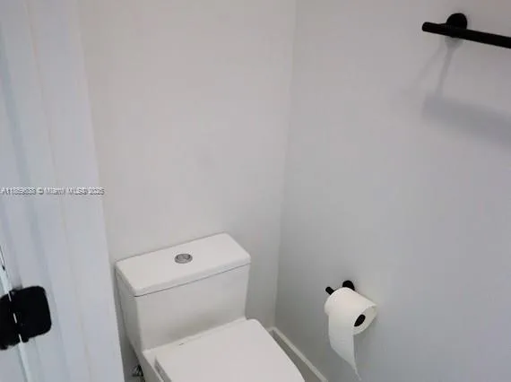 a white toilet sitting next to a shower