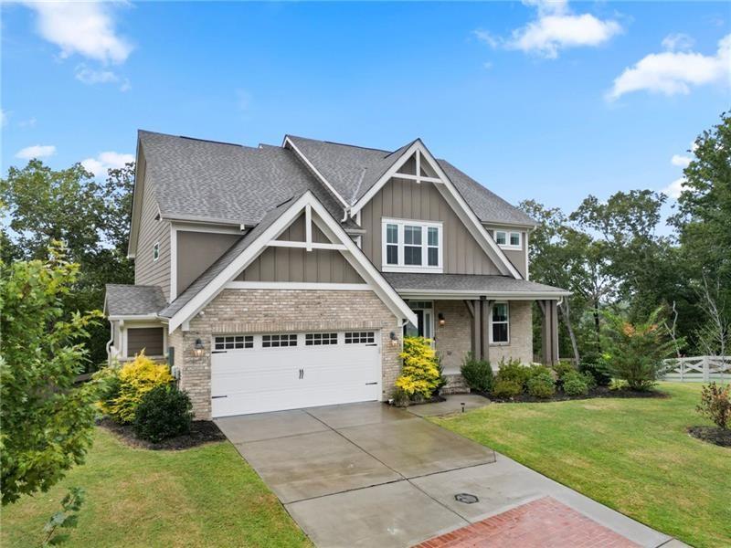 7945 Garnet Trace Ball Ground, GA 30107 - Photo 5 of 73 a front view of a house with a garden and yard