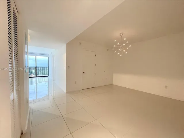 an empty room with chandelier fan