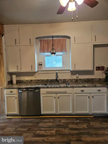 a kitchen with stainless steel appliances granite countertop a stove a sink and a granite counter tops with white walls