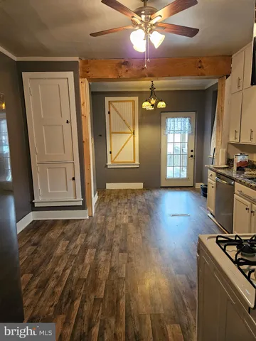 a view of a room with wooden floor and a kitchen