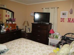 34 Monroe Street Inwood, NY 11096 - Photo 4 of 8 a room with a bed and a flat screen tv