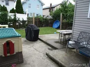 a view of a table and chairs in back yard of the house