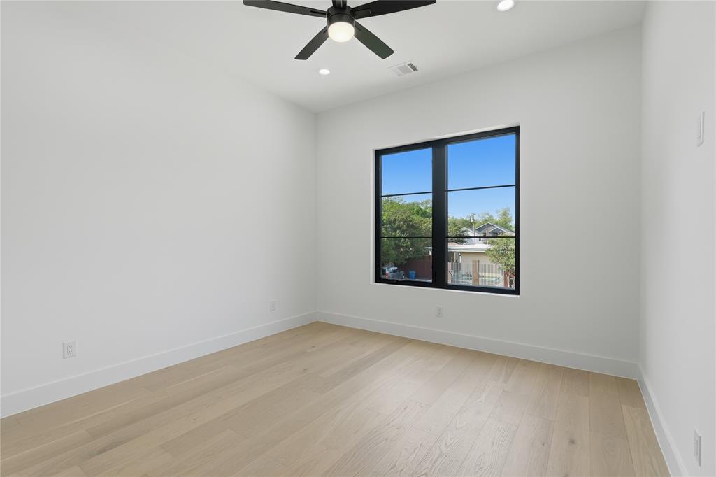 6038 Prospect Avenue Dallas, TX 75206 - Photo 28 of 40 Bright room featuring a large black-framed window, light wood-finish flooring, white walls, a ceiling fan, and recessed lighting