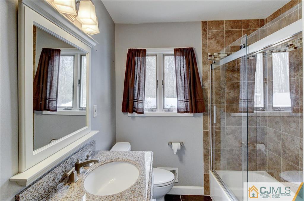 9 A Birch Drive Jackson, NJ 08527 - Photo 14 of 27 a bathroom with a granite countertop sink toilet a mirror and shower