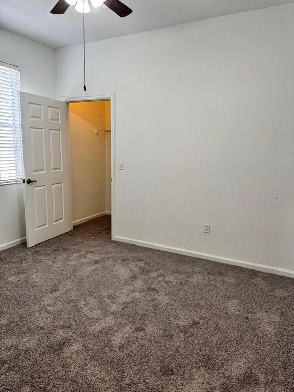 3001 Greystone Loop, Unit 201 Kissimmee, FL 34741 - Photo 12 of 26 an empty room with a ceiling fan and window