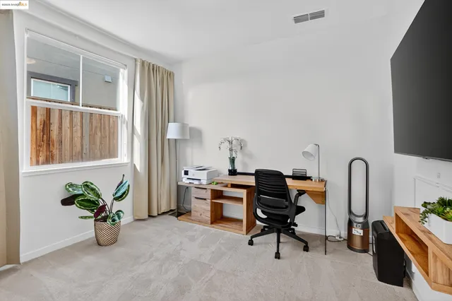 a view of a workspace with furniture and a window