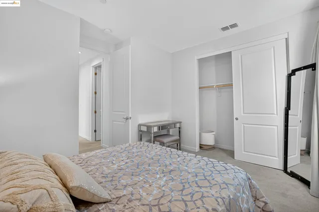 a bedroom with a bed and a refrigerator