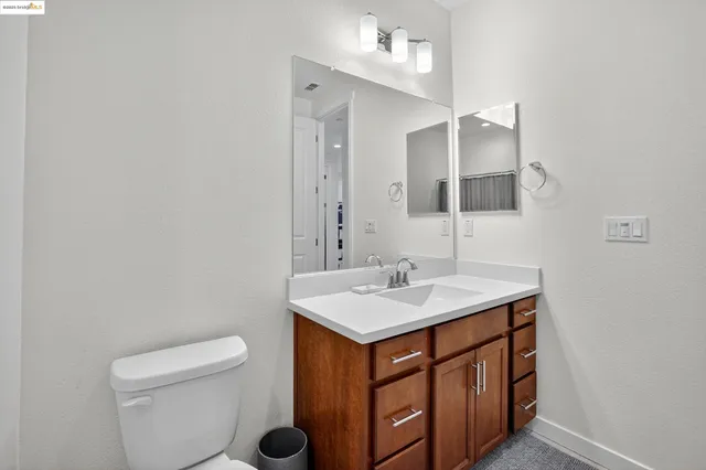 a bathroom with a sink a toilet and mirror
