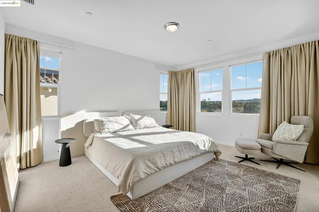 a bedroom with a bed and a couch next to a window