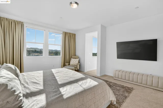 a bedroom with a large bed and a flat screen tv