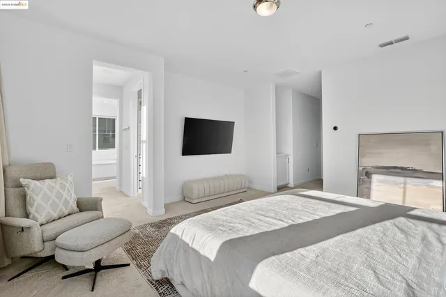 a spacious bedroom with a bed a couch and a flat screen tv