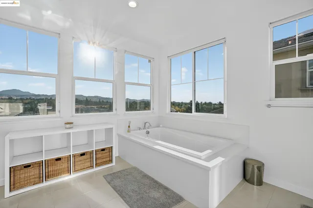 a white bath tub sitting in a en suite bathroom next to a window