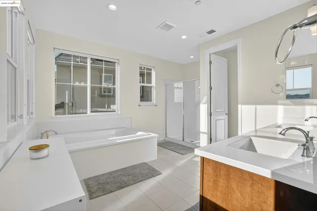 a bathroom with a tub sink and mirror