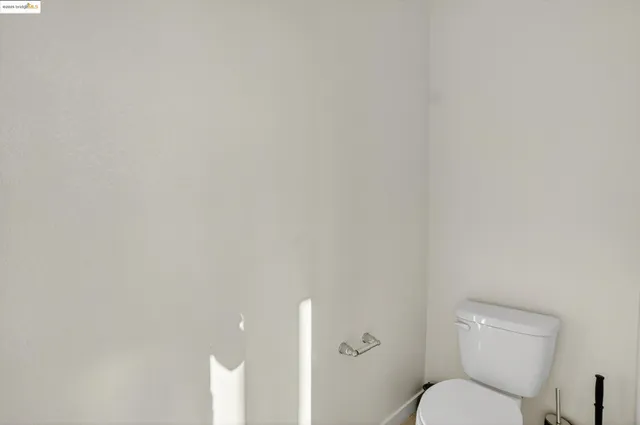 a white toilet sitting next to a white walls