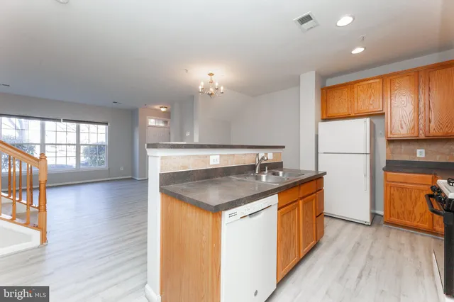 a kitchen with granite countertop a sink a counter space appliances and cabinets