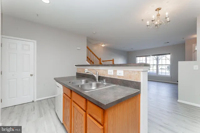a kitchen with stainless steel appliances granite countertop a sink a stove and a wooden floors