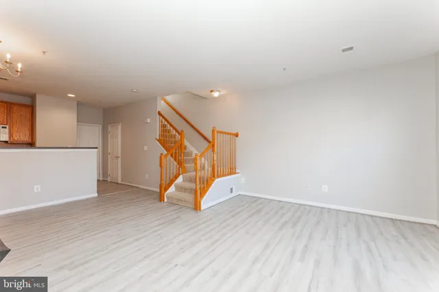 an empty room with wooden floor and white walls