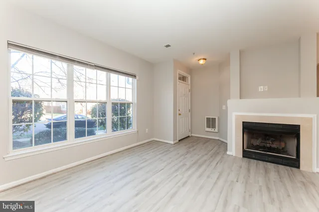 wooden floor fireplace and natural light in room