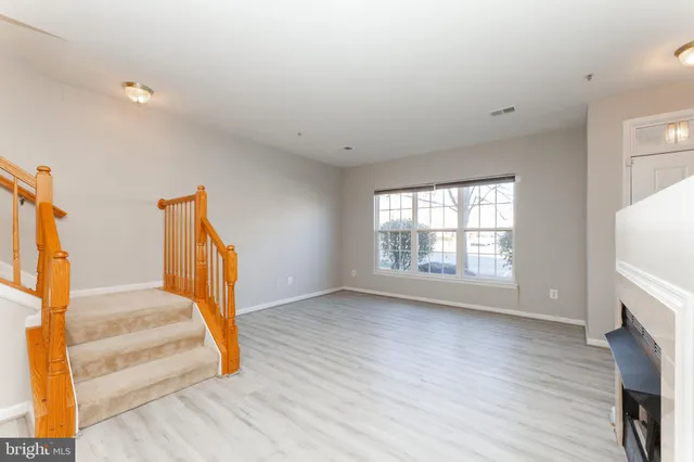 a view of a livingroom with wooden floor and a fireplace