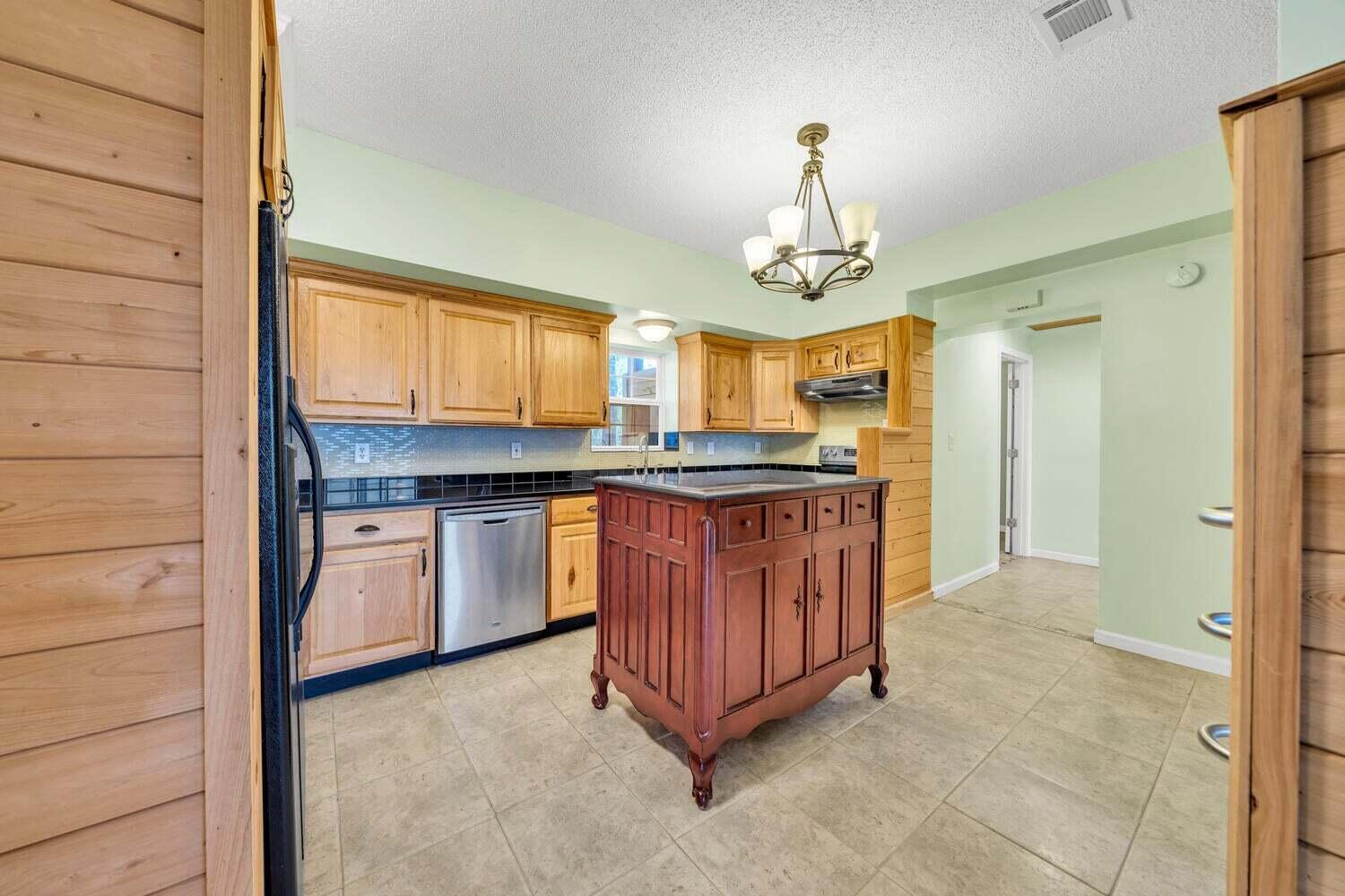 2030 Bay Grove Road Freeport, FL 32439 - Photo 6 of 22 a kitchen with stainless steel appliances granite countertop a stove a sink dishwasher and a refrigerator with wooden cabinets