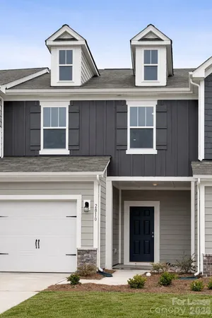 a front view of a house with yard and garage