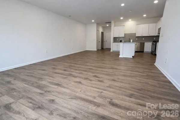 a view of kitchen with kitchen island wooden cabinets and refrigerator