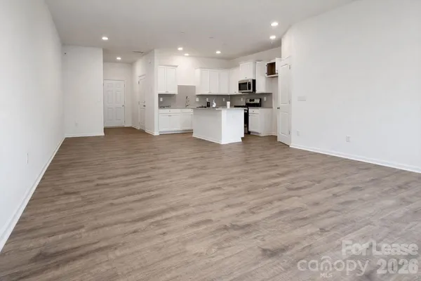 a view of kitchen with kitchen island stainless steel appliances refrigerator stove top oven and cabinets